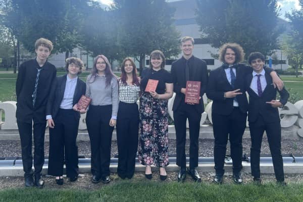 Debate_Team_17102025_600x400_01 A group of people posing outside with awards.