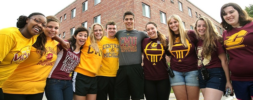 A group of students wearing Central Michigan University apparel and smiling for a group photo