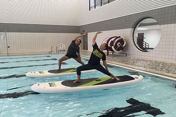 Demonstration of paddle board yoga at the pool in the SAC.