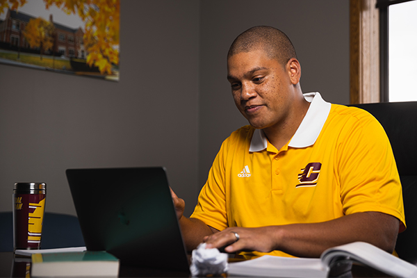 Central Michigan University Online adult learner studying with a laptop.