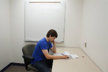 A student sitting and reading in the individual study room at the Central Michigan University - University Libraries - Park Library