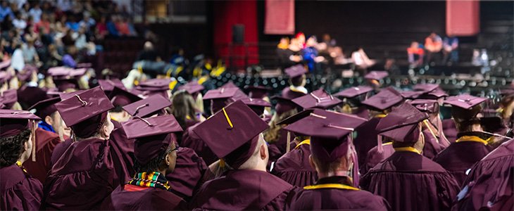 CMU commencement ceremony with shot of students from the back, and faculty and guest blurred in the background