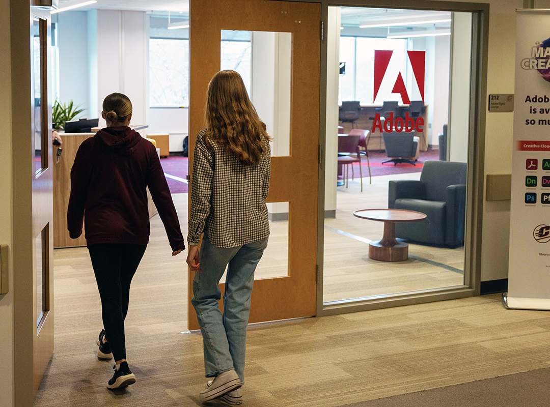 Two students walking into the Adobe Digital Lounge entrance