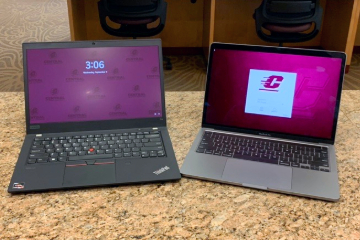 A black ThinkPad laptop computer on the left and a silver MacBook laptop on the right, both open on pink quartz countertop.