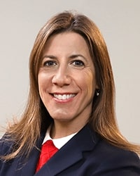 Dawn Decker wearing a navy blue jacket and smiling while posing for a professional headshot.