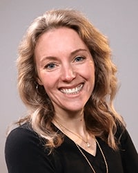 Rachael Nelson wearing a black shirt and smiling while posing for a professional headshot.