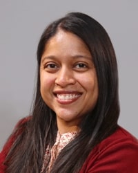 Shilpa Alamuri wearing maroon and smiling while posing for a professional headshot.