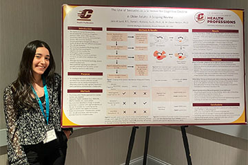 CMU graduate student, Jana Al Judi, stands next to her research poster.