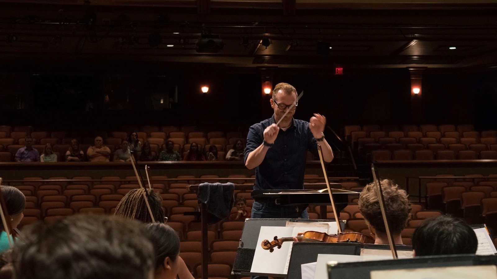 New CMU school of music faculty, Keith Dodson, conducting an orchestra.