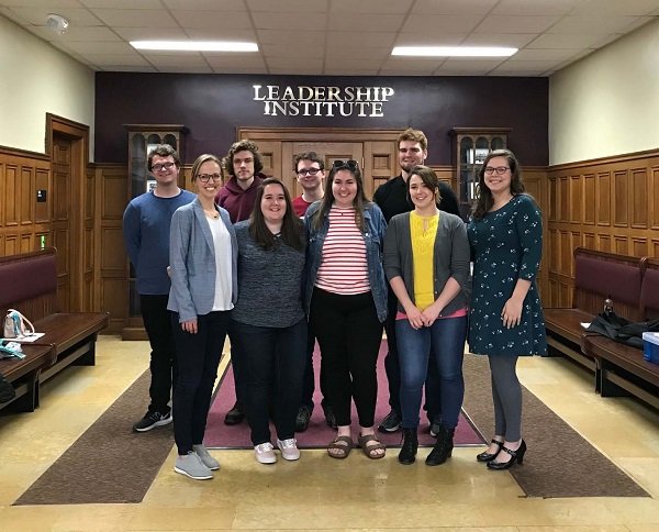 A group of people posing for a group picture in front of the Leadership Institute at Central Michigan University.