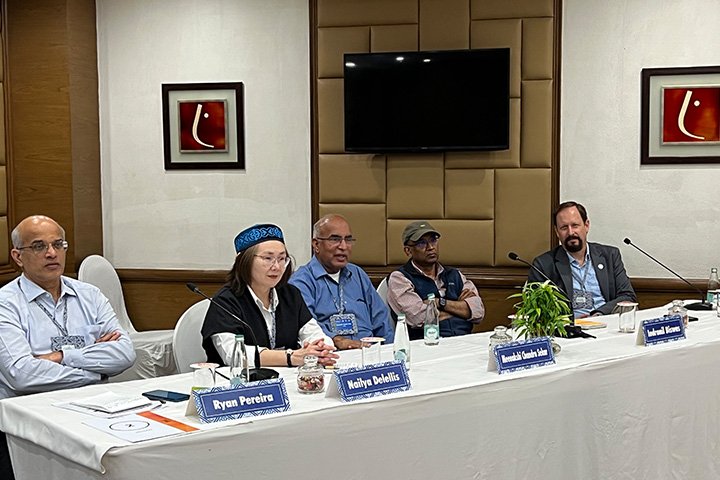 Five professionally dressed people sitting at a panel table.