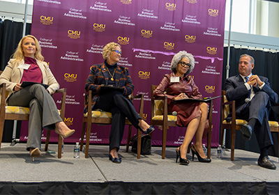 Photo of the Women in Business Panel that was part of the keynote presentation for the 2023 Dialogue Days event in Grawn. The panel consists of four people. They are sitting on a stage in front of a CBA backdrop.