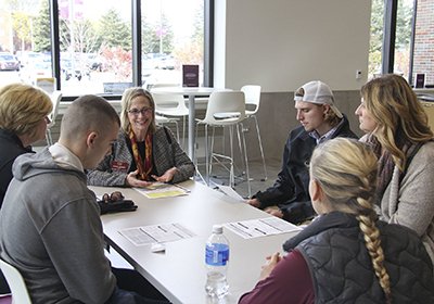 CBA students talking to faculty member