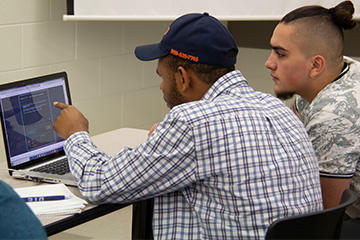 Two cyber security students participate in cyber capture-the-flag event.