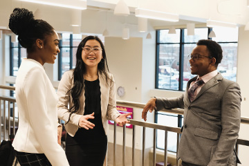 Gen Z business students chat in the Grawn Atrium.