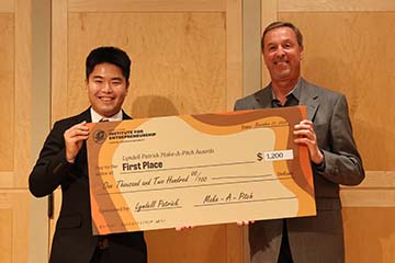 Masaki Hara receives award check for top elevator pitch.