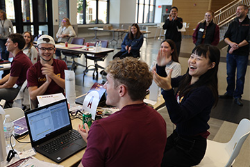 Students celebrating victory clapping within the College of Business Administration at Central Michigan University!