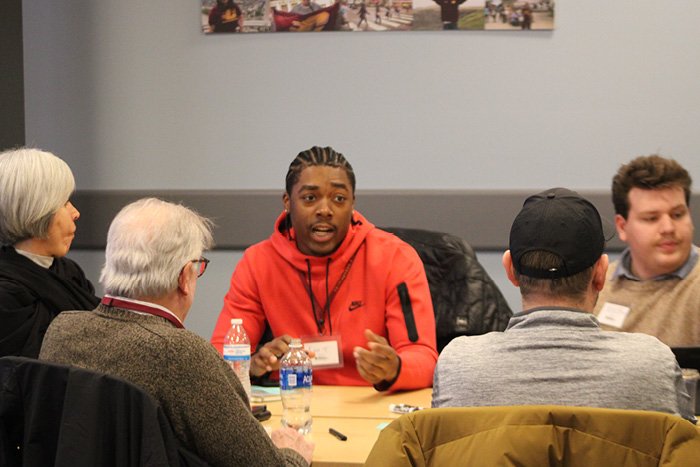 Two students sitting at a table with three faculty members during a new venture challenge workshop