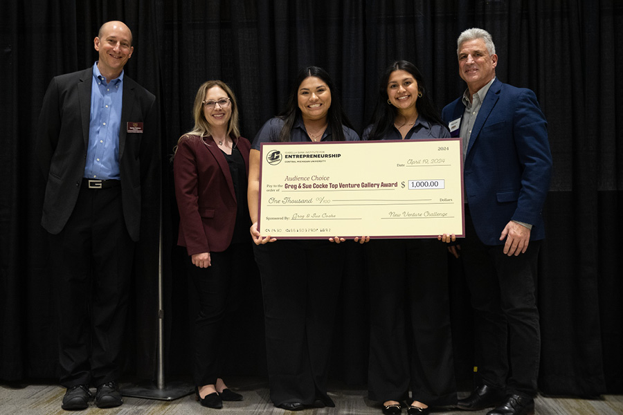 Two students, two faculty members and a donor standing in front of a winning award check.