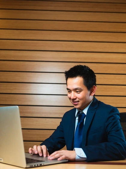 a man in a suit and tie working on a laptop