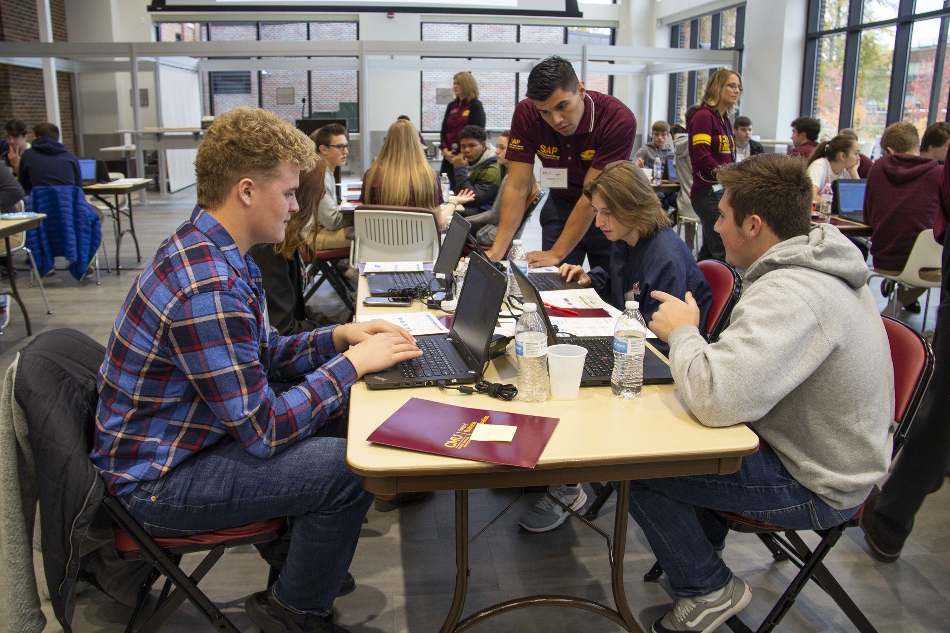 High School ERPSim Central Michigan University SAP students coaching high school juniors and seniors on how to use SAP and enterprise research management system