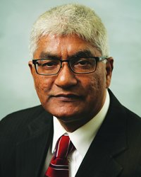 Professional headshot of Mohammad Jafferany wearing a black blazer, white shirt and red tie.