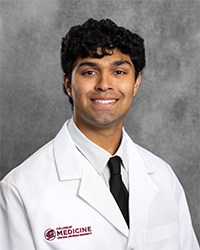 Kothari, Tej 200x250 A male CMU College of Medicine medical student wearing his white coat as he smiles for the camera.