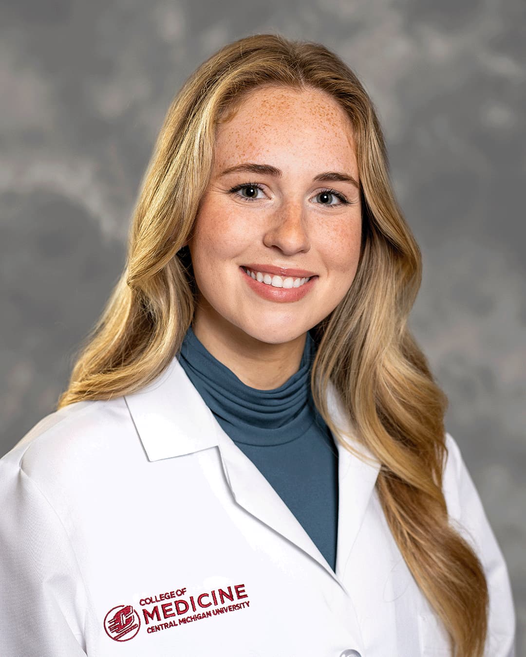 Maryakhin, Danna 200 x 250 web A female CMU College of Medicine medical student with blonde hair is wearing her white coat as she smiles for the camera.