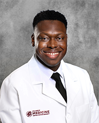 Wright, Enioluwa 200x250 A male CMU College of Medicine medical student wearing his white coat as he smiles for the camera.