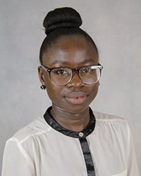 A professional headshot of Oluwayemisi Oyeleke in light attire against a gray background.