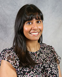 Headshot of Amanpreet Khosa wearing a black print top.