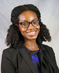 Headshot of Nwamaka Merah wearing a black blazer and a black and blue print top.