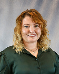 Headshot of Ashley Elliott wearing a green shirt.