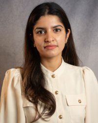 A woman with long hair wearing a cream shirt.