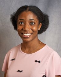 A woman in a pink shirt with black bowties.