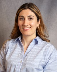 A woman with long hair wearing a blue and white striped shirt.