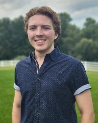 Headshot of Jacob Simkins wearing a blue short sleeved button-down.