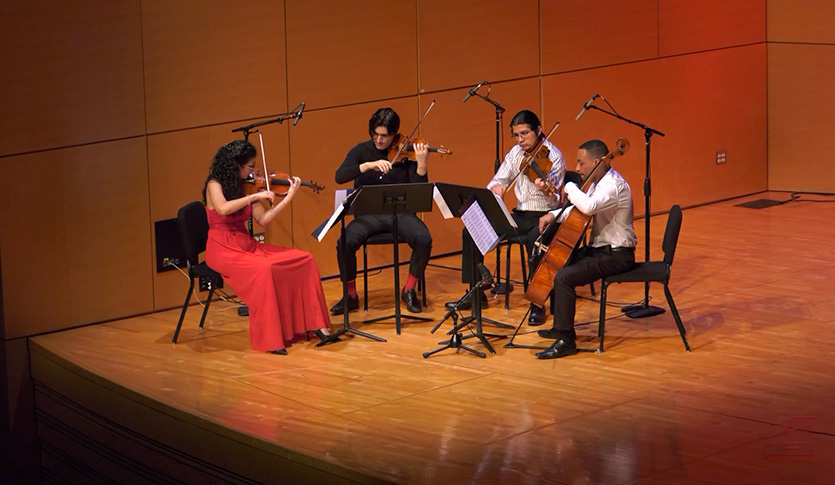 The CMU Graduate String Quartet is playing music in Staples Family Concert Hall.