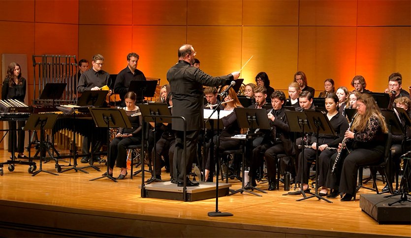 A picture of the Central Michigan University Symphonic Wind Ensemble in black attire performing at Staples Family Concert Hall.