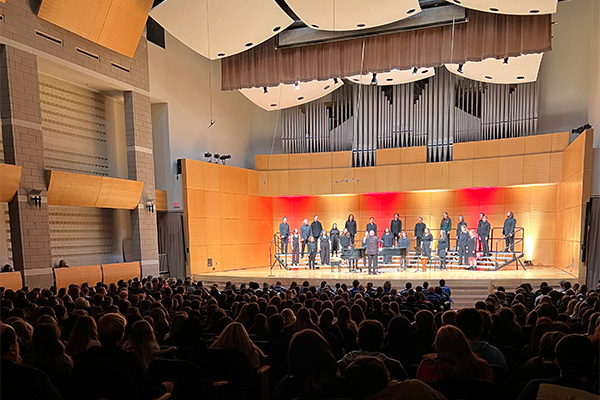 A picture of a choir performing to a packed audience at Staples Family Concert Hall.