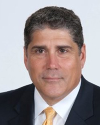 Headshot of Ed Fernandez with a light grey backdrop.
