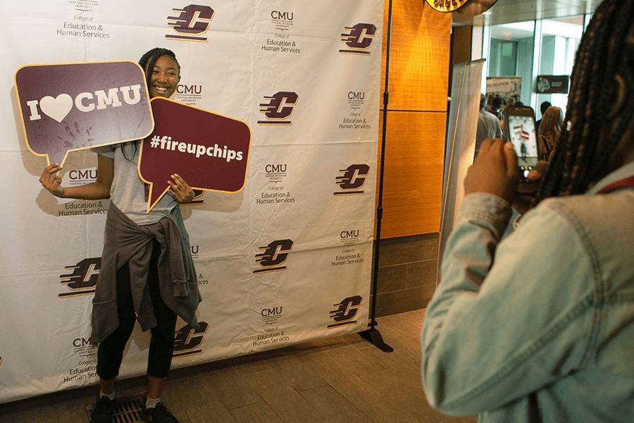 Student posing for a photo at a selfie station