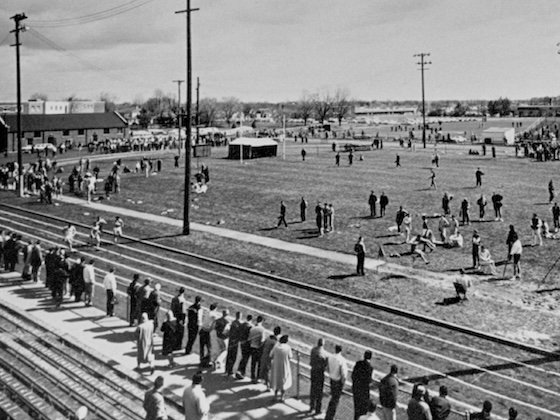 A historic black and white photo of the alumni field and track outside of Finch Fieldhouse.