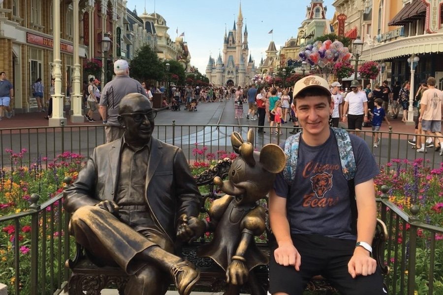 A Disney Program student posing in front of the Magic Castle at Disney World.