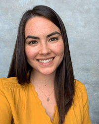 Sarah Manacek, a graduate from the Doctorate in Educational Technology program at Central Michigan University, in a gold blouse.