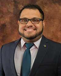 Closeup image of Eric Pouncil wearing a suit and tie.