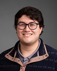 Closeup image of Nate Roselle wearing a dark striped shirt with tan collar.