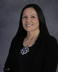 Closeup image of Christina Otto wearing a black shirt and sweater.