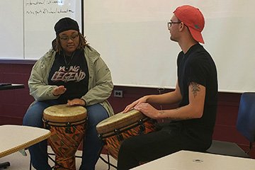 Derrick VanWay (right) and Armarion Bates (left) play djembe drums during VanWay's presentation on West African drumming styles