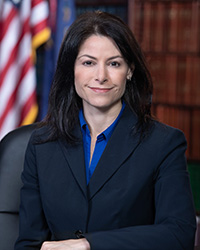 Closeup image of Michigan Attorney General Dana Nessel wearing a dark suit jacket and blue shirt.